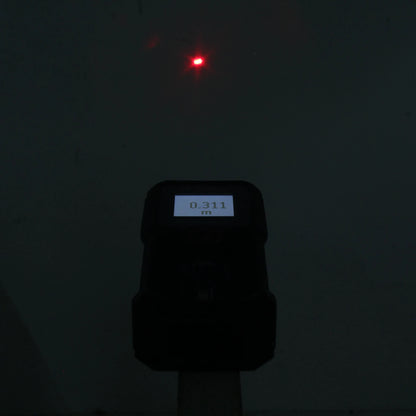 Medidor láser Bosch de distancia con punto rojo y pantalla digital mostrando 0.311 m.